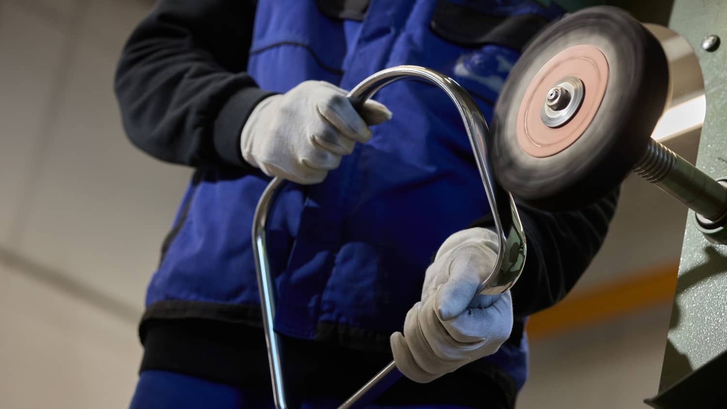 Ein Handwerker poliert den Aluminium-Rahmen eines Stuhls wieder auf